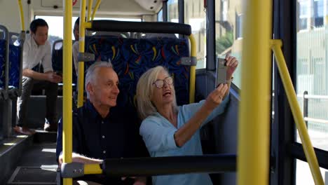 pareja de ancianos tomando una selfie con el teléfono móvil mientras viajan en el autobús 4k