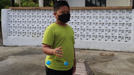 Indonesischer-Junge,-Der-&quot;lato-lato&quot;-Spielt,-Beliebtes-Spielzeug-In-Indonesien