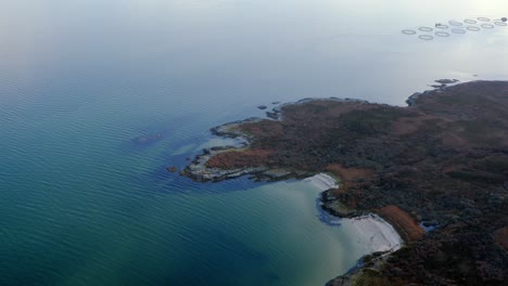 AERIAL---Fishing-nets-close-to-the-beach,-Isle-of-Gigha,-Kintyre,-Scotland,-lowering