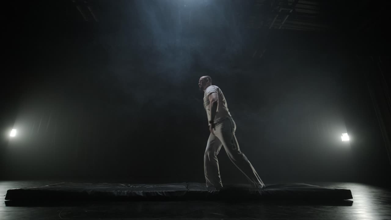 Acrobacias de Capoeira em um Estúdio Escuro