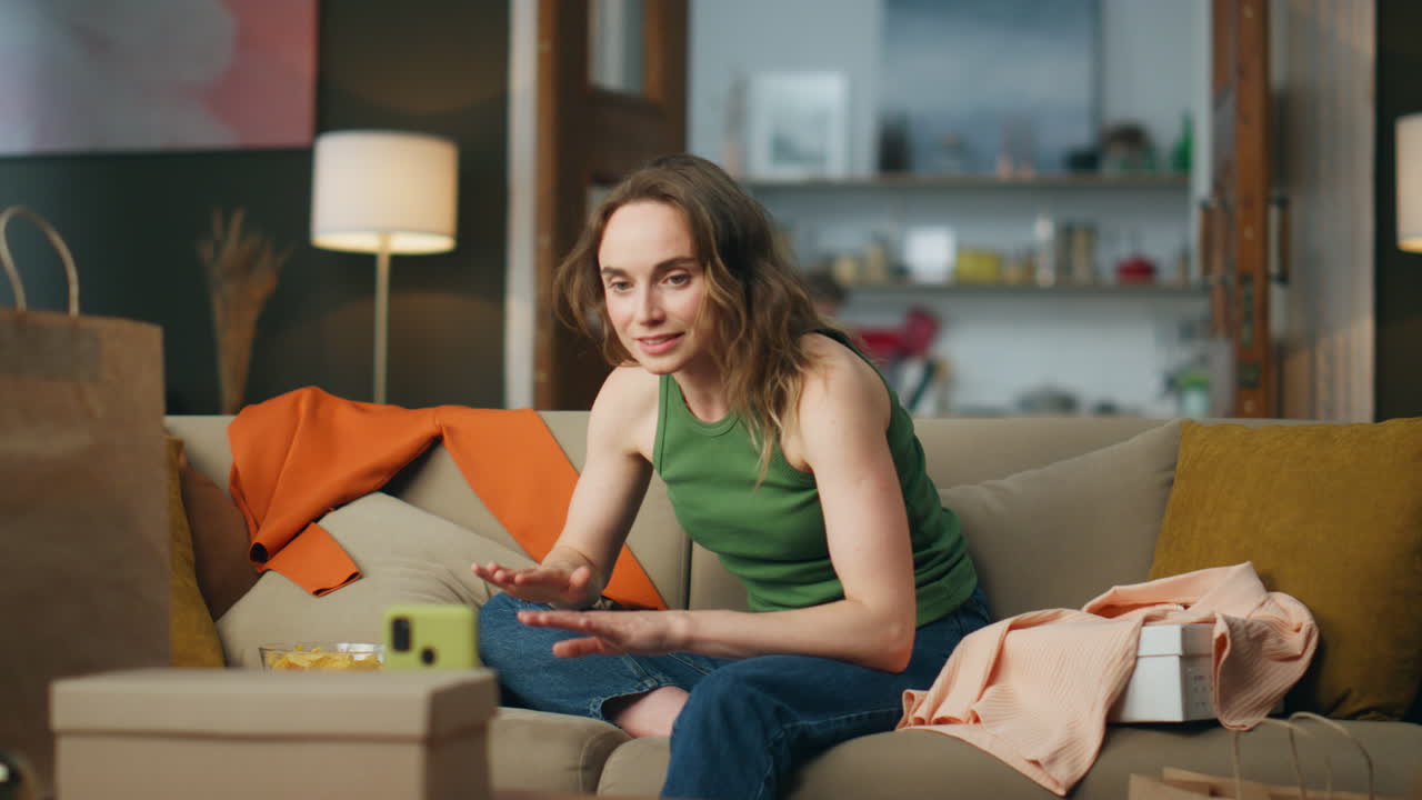 mujer hablando grabando un blog de teléfono inteligente en el sofá. blogger de compras gestando las manos