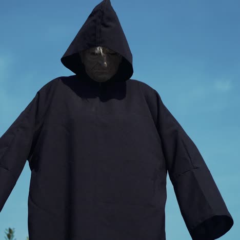 eerie witch watches the camera. halloween costume.