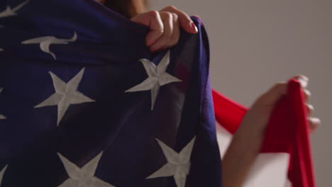 close up studio portrait shot of woman wrapped in american flag celebrating 4th july independence day 1