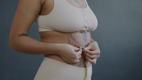 woman measuring waist with measuring tape