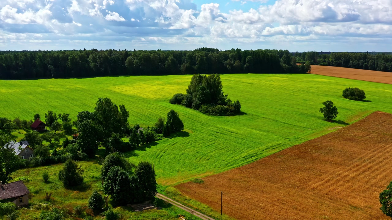 Aerial view of countryside landscape with fields, pond, and farm buildings