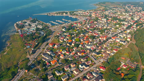 Drohnenaufnahme-Von-Jastarnia-Mit-Jachthafen-In-Polen-An-Einem-Sonnigen-Sommertag-Mit-Bucht-Im-Hintergrund