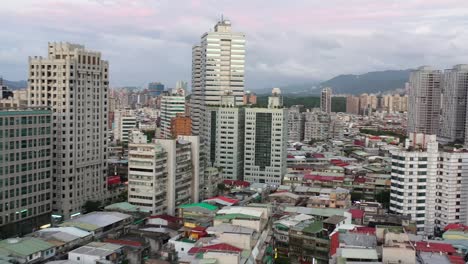 Lufteinspielung,-Drohne-Fliegt-Durch-Das-Yongchun-Viertel-Und-Erfasst-Niedrige-Wohngebäude-Und-Hochhaus-Wolkenkratzer-Im-Innenstadtbezirk-Xinyi,-Hauptstadt-Taipei,-Taiwan