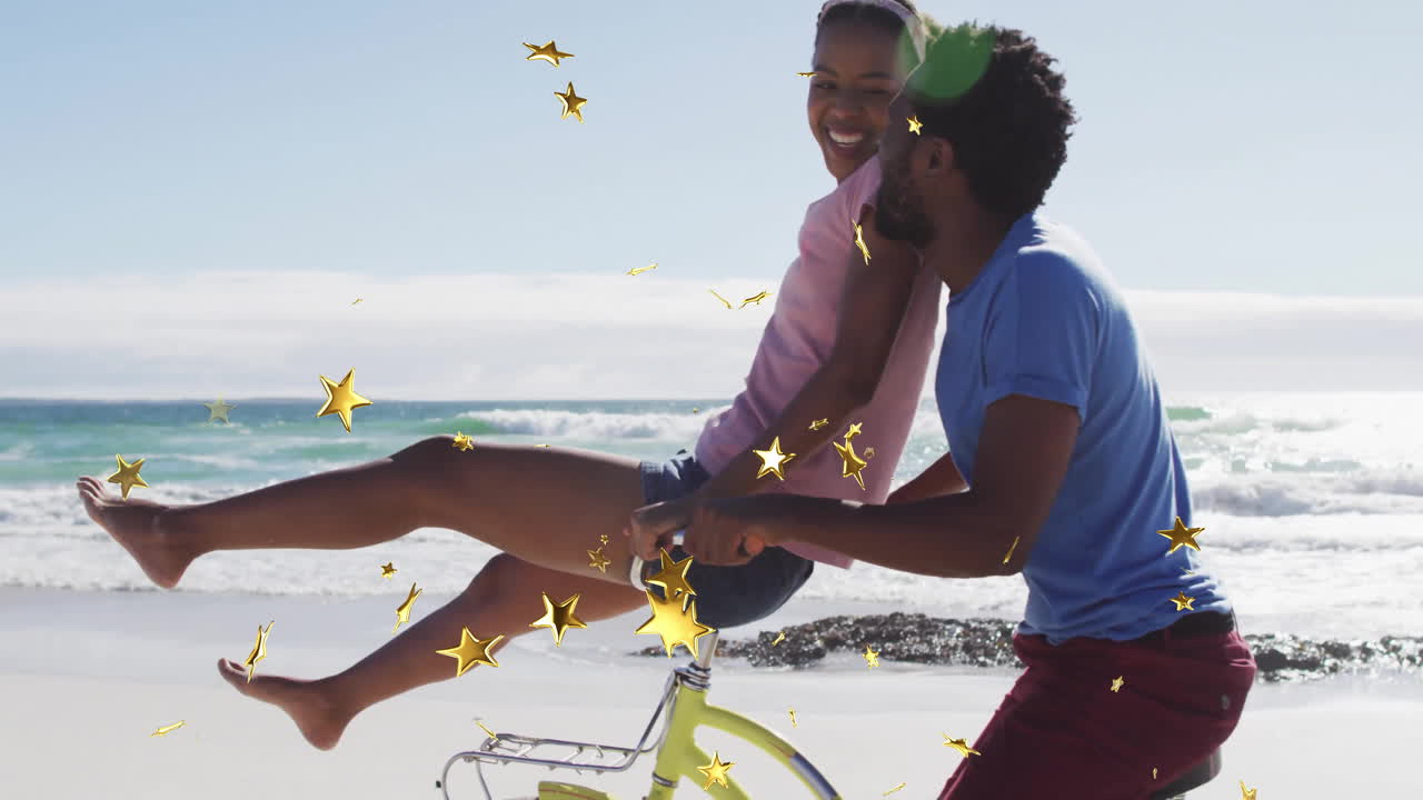 Couple enjoying beach bicycle ride with golden stars animation overlay