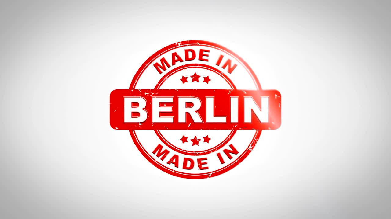 Laget i BERLIN Signert Stemplingstekst Trestempel Animasjon. Rødt blekk på ren hvit papirbakgrunn med grønn matt bakgrunn inkludert