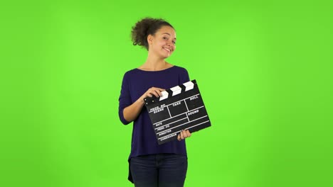 mujer con clapperboard en la pantalla verde