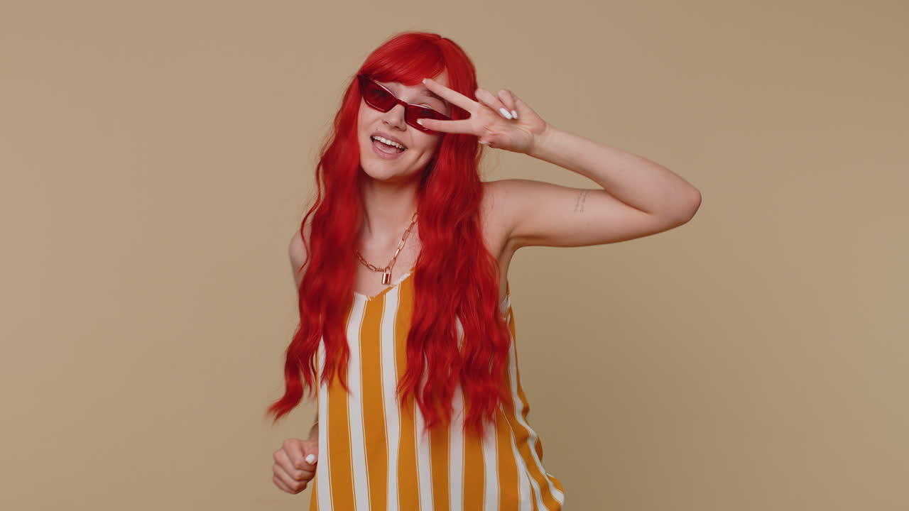 재미있는 소녀 음악을 듣고 미소 짓고 디스코 파티 음악에 춤추고 리적으로 움직이는 손이 재미있습니다.