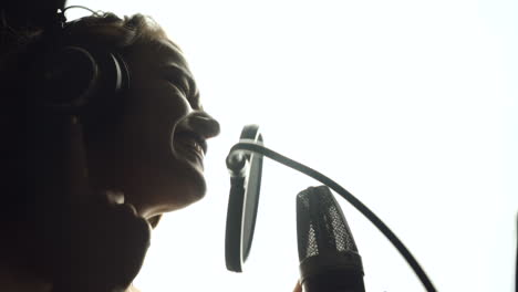 close-up of girl in headphones singing a song. professional recording studio
