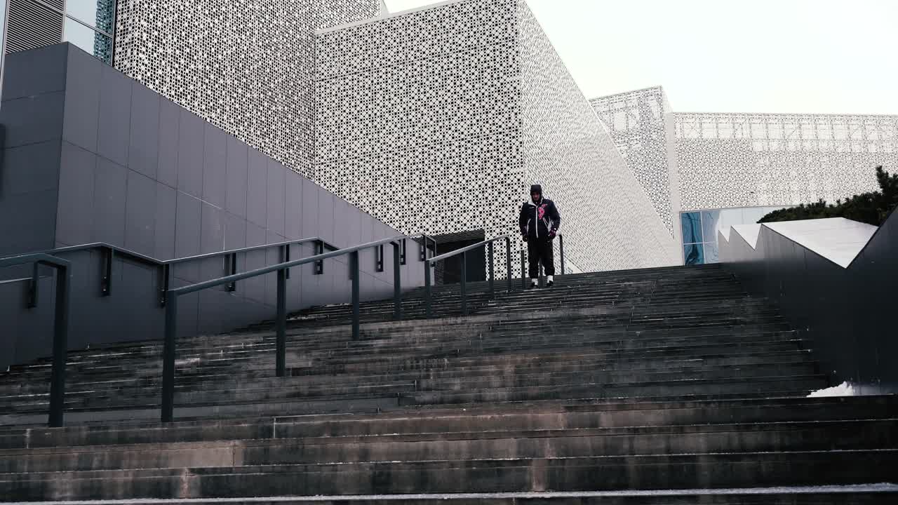 hombre subiendo las escaleras frente a la arquitectura moderna