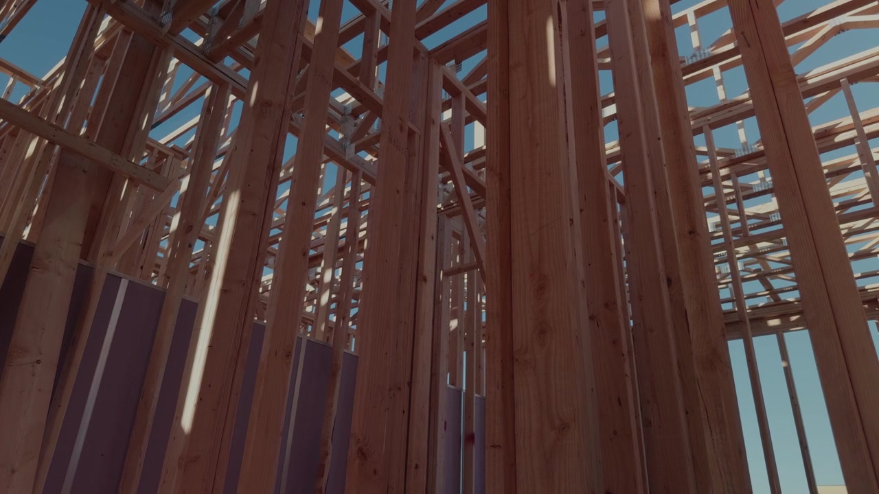 Panoramique rotatif lent de gauche à droite à l'intérieur d'une ossature de bâtiment en bois apparente.