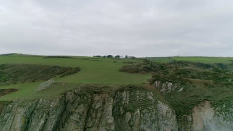 Aerial-tracking-backwards-out-to-sea-revealing-an-amazing-stunning-south-Devon-coastline,-Just-south-of-Dartmouth-near-the-inner-combe-rocks