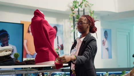 Retail-clerk-puts-clothes-on-mannequin