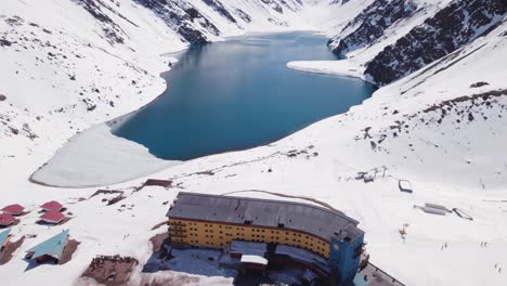 Fly-Over-Portillo-Ski-Resort-And-Hotel-Accommodations-Towards-The-Lake-In-Las-Condes,-Chile