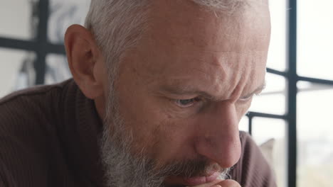 Close-Up-Of-An-Upset-Middle-Aged-Man-Worrying-And-Thinking-About-Something-While-Sitting-On-Sofa-At-Home