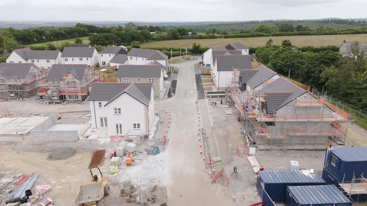 Drone view of a new housing estate partially built in Devon, UK, highlighting the construction progress and surrounding fields