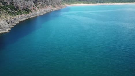 drone aerial over tropical blue water and beach moving forward pan up