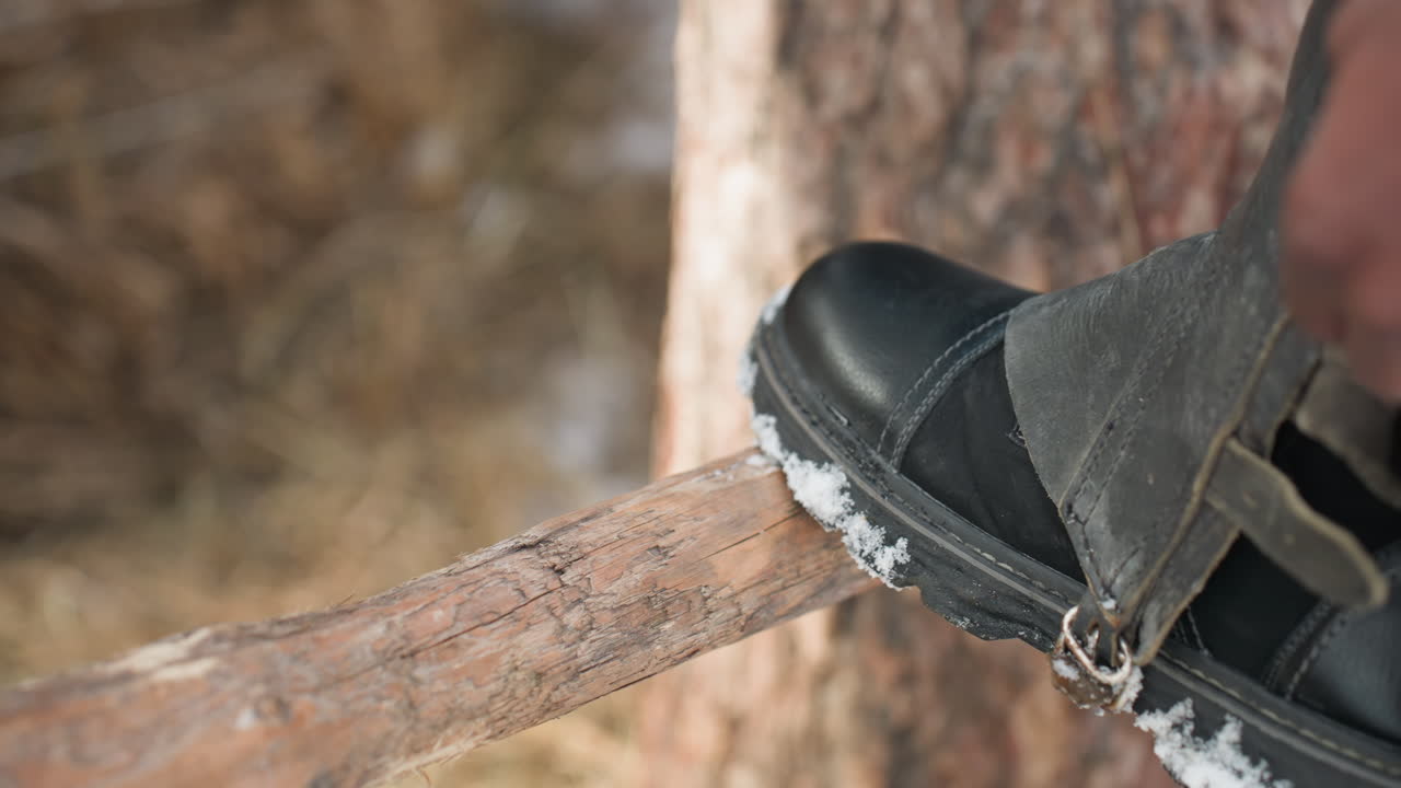 alpinista colocando los crampones de forma segura, aventurero alpino fijando los crampones metálicos a las botas de montaña con cuidado, escalador de montaña abrochando diligentemente los crampones a unas botas resistentes para conquistar laderas heladas