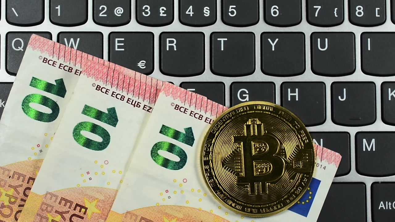 Bitcoin e denaro in euro su tastiera di computer