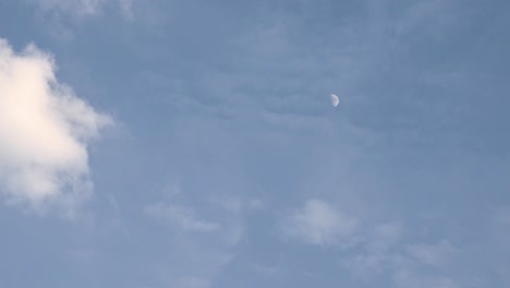 Luna-En-Su-Primer-Cuarto-De-Lapso-De-Tiempo-Como-Se-Ve-Antes-Del-Anochecer-Con-Nubes-Casi-Cubriéndola-En-El-Lado-Derecho-Del-Marco