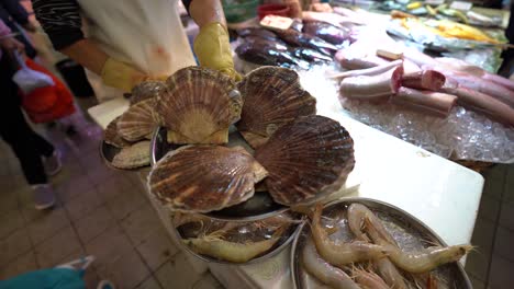 toma de pov del mercado asiático de carne de pescado y marisco donde el comerciante muestra diferentes tipos de marisco