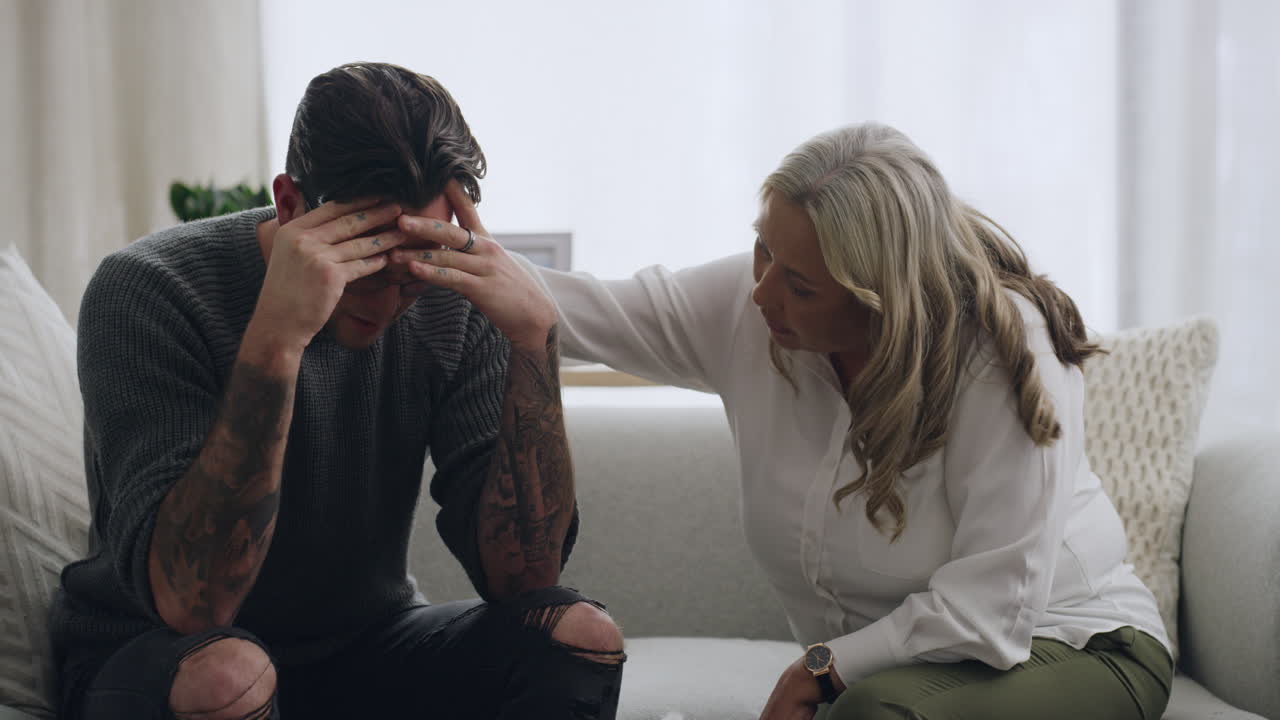 hombre llorando y siendo consolado por un psicólogo