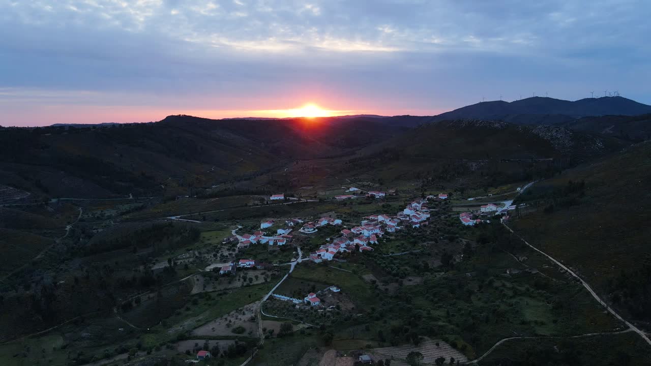 vista de drones volando a través de un pequeño y hermoso pueblo en las montañas durante la puesta de sol