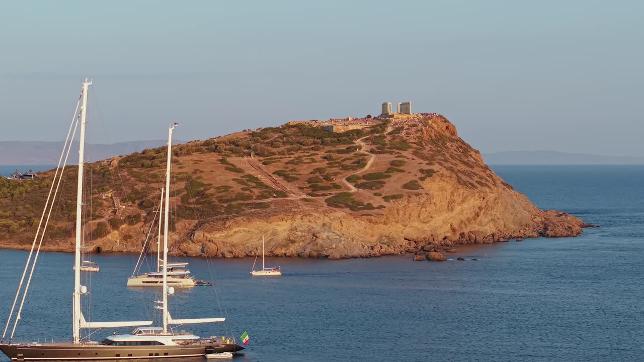Revealing a luxury sailing boat with the Temple of Poseidon in the background during sunset, blending ancient heritage with maritime elegance