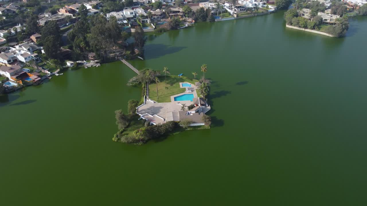 video de drones de una pequeña casa club en una isla en medio de una laguna o lago