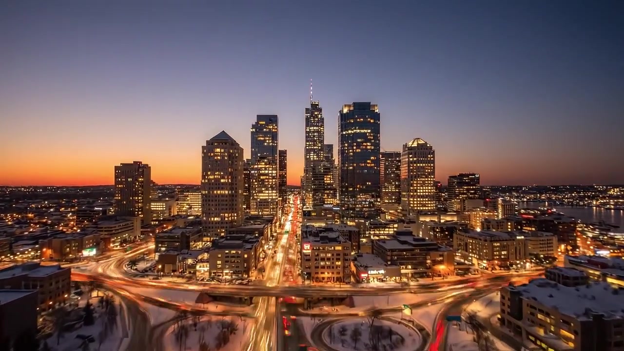 Paisaje urbano nocturno: Una asombrosa transformación de las luces de la ciudad y el perfil urbano bajo el paso elevado, con arquitectura moderna y un sereno paisaje invernal.