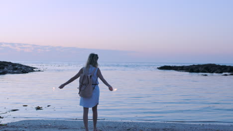 woman, beach walk and sparkler celebration