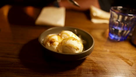 person eating ice cream with caramel sauce