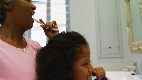 abuela y nieta cepillándose los dientes en el baño 4k