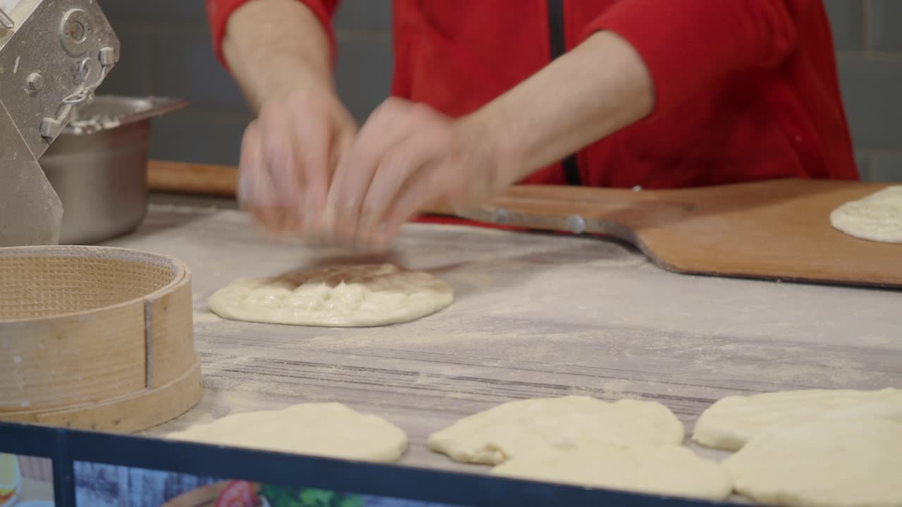 Close-up of Chef's Hands Shaping Fresh Dough on a Floured Counter