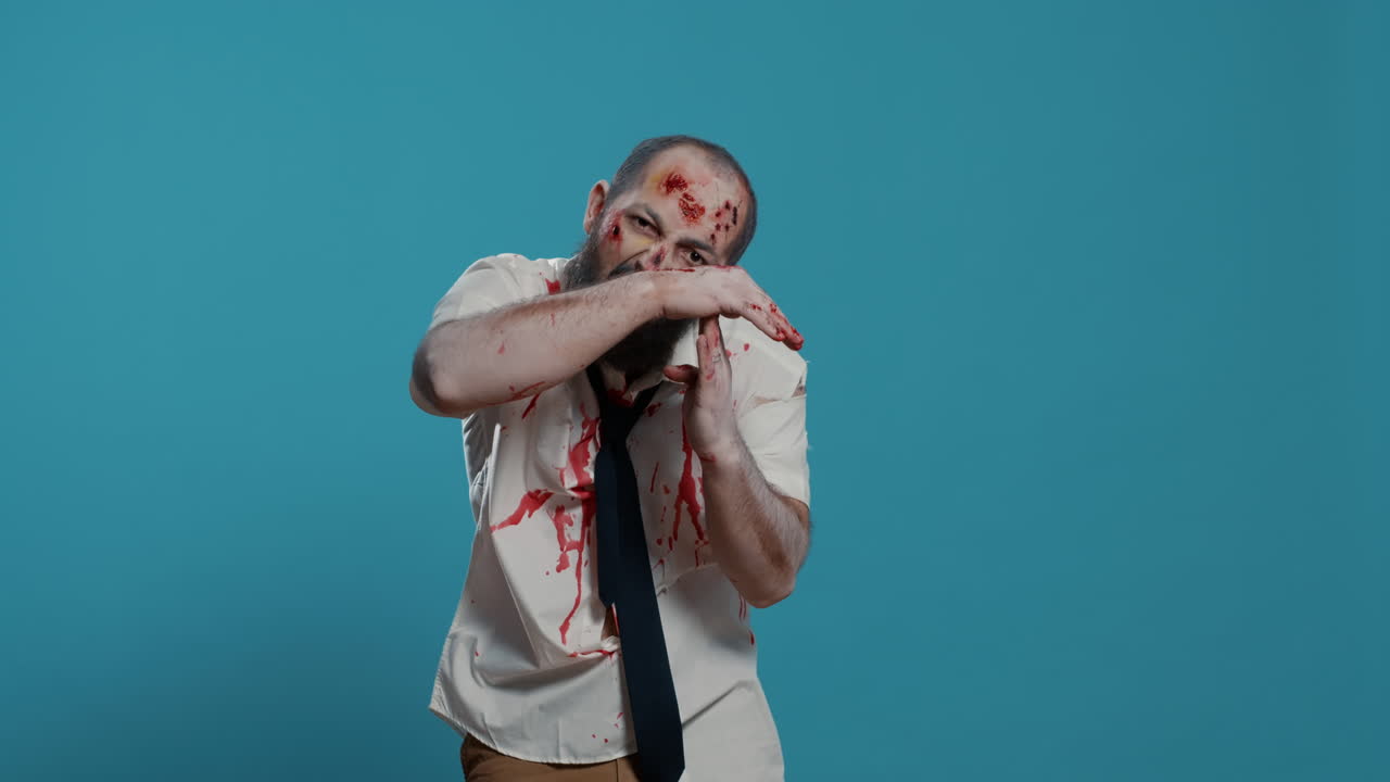 Frightening evil looking zombie making timeout hand gesture on blue background