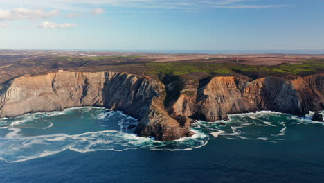 aerial dolly forward of beautiful algarve coastline with cliff rocks and splashing ocean water in bay