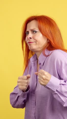woman with angry expression clenching fists ready for confrontation