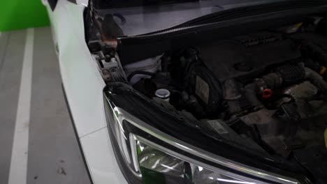 mechanic filling the tank of windshield wiper fluid in garage, 4k