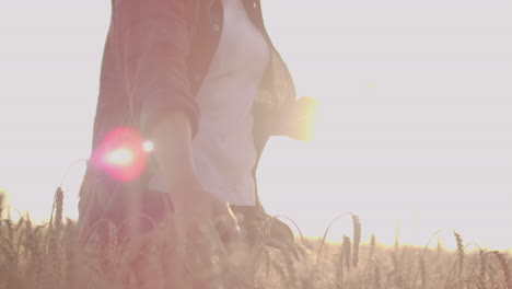 Joven-Agricultora-Con-Camisa-A-Cuadros-En-Campo-De-Trigo-Al-Fondo-Del-Atardecer.-La-Niña-Usa-Una-Tableta-Para-Cosechar.