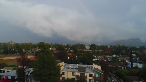 4k aerial drone footage of studio city, ca with rain, cloudy skies and a rainbow