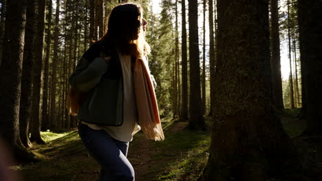 mujer caminando en un bosque de pinos