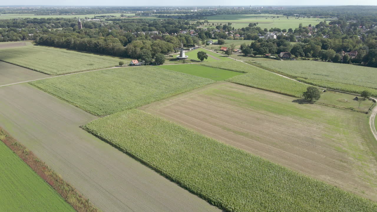 Wide aerial dolly of traditional windmill surrounded by farmland