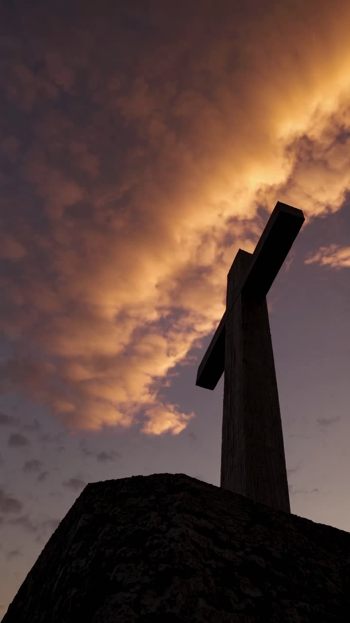 Silueta de una cruz con un cielo dramático al atardecer, capturada desde un ángulo bajo