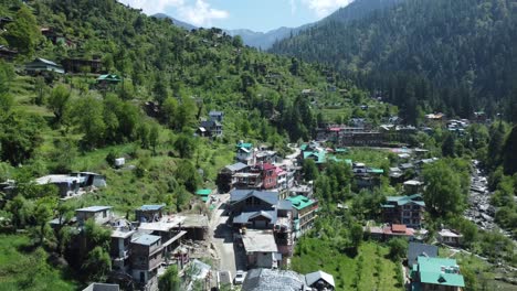 aerial view short of jibhi himachal pradesh in india. houses and trees in the mountainous area. faguli festival is one of the biggest festival in jibhi. the traditional houses here have stone roofs.