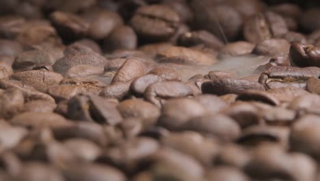 cerrar la toma en cámara lenta de asar granos de café mientras el humo comienza a aparecer resaltando el hermoso aroma y los sabores