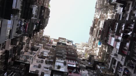 ángulo-Bajo-De-Edificios-De-Apartamentos-Para-Residentes-De-Gran-Altura-En-Hong-Kong-En-Quarry-Bay,-Mansión-Montana,-Toma-Cinematográfica-Giratoria