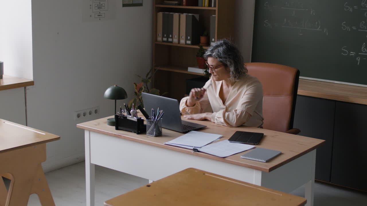 Teacher working on a laptop in a classroom